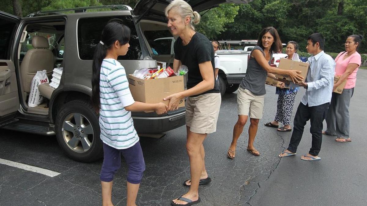 Susan Romaine, second from left, and Christine Cotton, third from left, deliver food to Burmese refugee families in Carrboro. The women, along with Debbie Horwitz, founded the food relief agency PORCH in 2010. The agency now serves 380 families a year.
