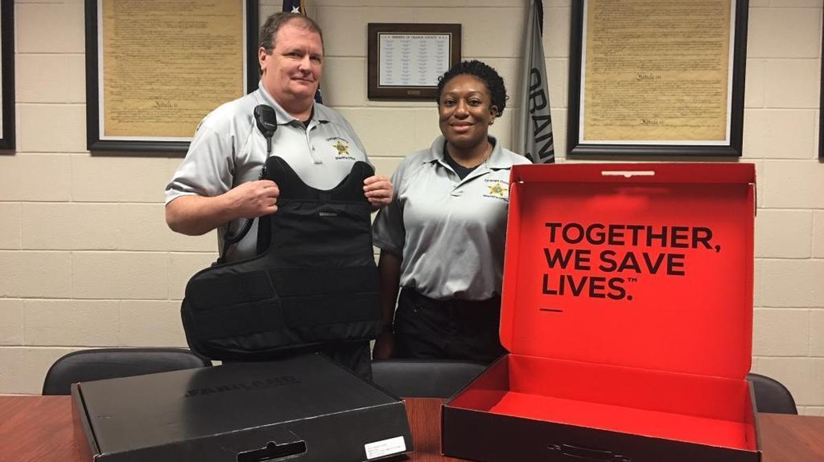 Deputy Marvin F. Ivey and Detention Officer Shavon Bradsher display one of the new protective vests purchased for the safety of Orange County Sheriff’s Office, Detention Center staff.