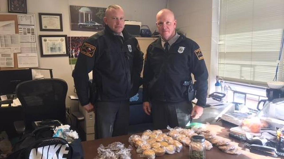 State Highway Patrol troopers T. Hussey (left) and M.D. Dodson (right) pose behind seized contraband which includes a “very old” gun and muffins baked full of marijuana.