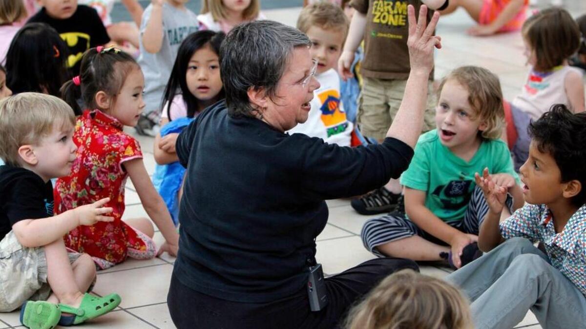Jody Cassell, center, dance and movement instructor with the American Dance Festival community studio in Durham leads a group of children in a July 2013 rhythm and creative movement exercise while telling them an adventure story at a weekly event at University Place in Chapel Hill.