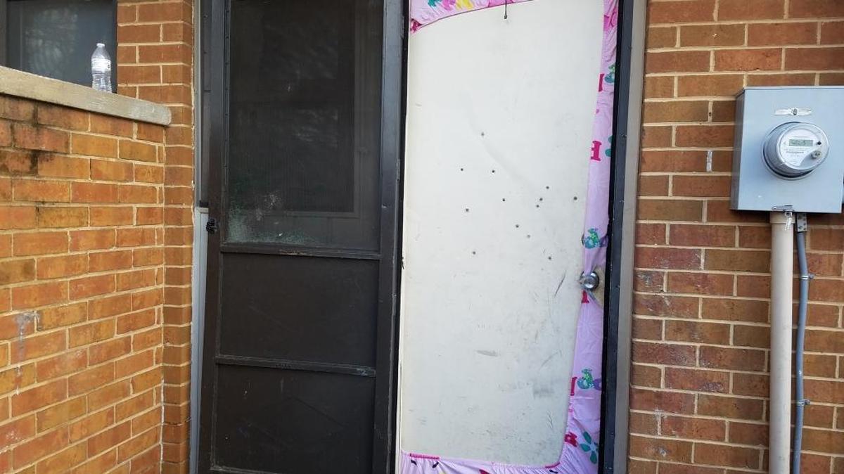 Thirteen bullet holes mark the townhouse door where a 22-year-old pregnant woman and a 26-year-old man were shot early Tuesday, January 23, 2018.