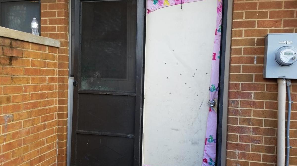Thirteen bullet holes mark the townhouse where a 22-year-old pregnant woman and a 26-year-old man were shot early Tuesday, January 23, 2018.
