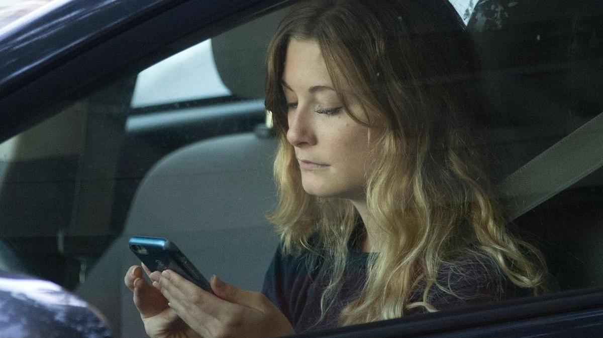 FILE - In this file photo, a driver uses her mobile phone while sitting in traffic.