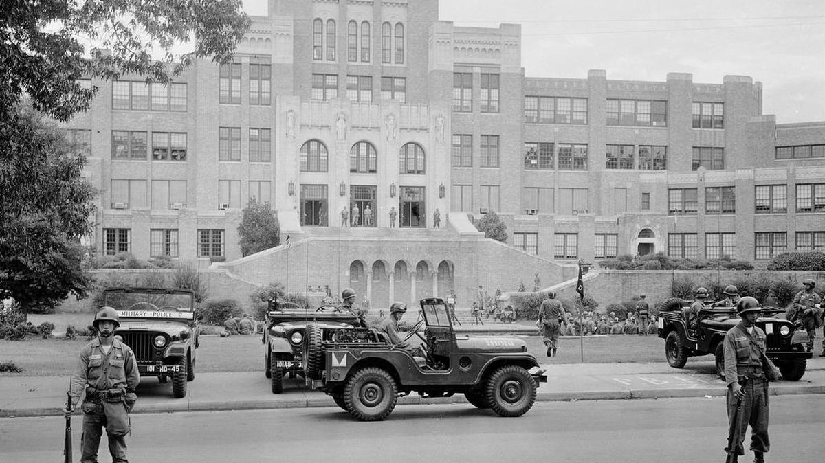 In this Sept. 26, 1957 file photo, members of the 101st Airborne Division take up positions outside Central High School in Little Rock, Ark. The troopers are on duty to enforce integration at the school. Officials say newly unveiled plans to commemorate the 60th anniversary of nine African-American students desegregating Little Rock Central High School will reflect on the progress made in educating students of diverse backgrounds.