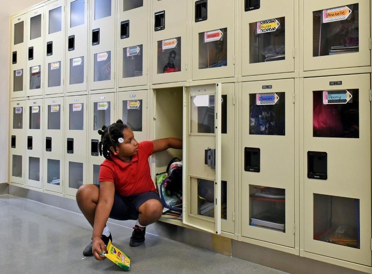Mirakle Jones,7, retrieves a book from her locker at Thales Academy in Knightdale, N.C. Thursday, July 20, 2017. Traditional public schools in North Carolina are now seeing a drop in enrollment at the same time that home schools, charter schools and private schools like Thales are seeing enrollment gains.