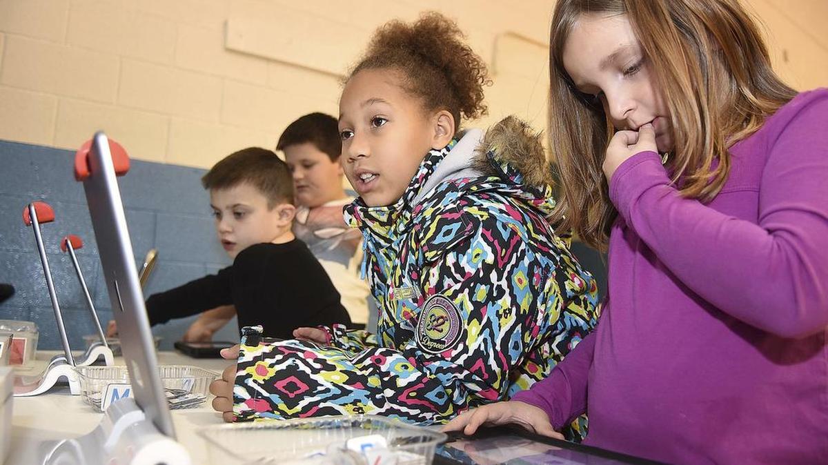 In this Wednesday Nov. 11, 2017 photo, second graders, from left, Aydin Prichett, Kholton Toma, Niema Laster and Isabella Templeton work at the basketball vocabulary station during a Legacy Lab class at Cranberry-Prosperity School in Beckley W.Va. They are working at one of the four stations called, “Dash’s Basketball.” Cranberry Prosperity has been awarded with the status of being an “Apple Distinguished School” for being top notch with technology use in their classrooms.