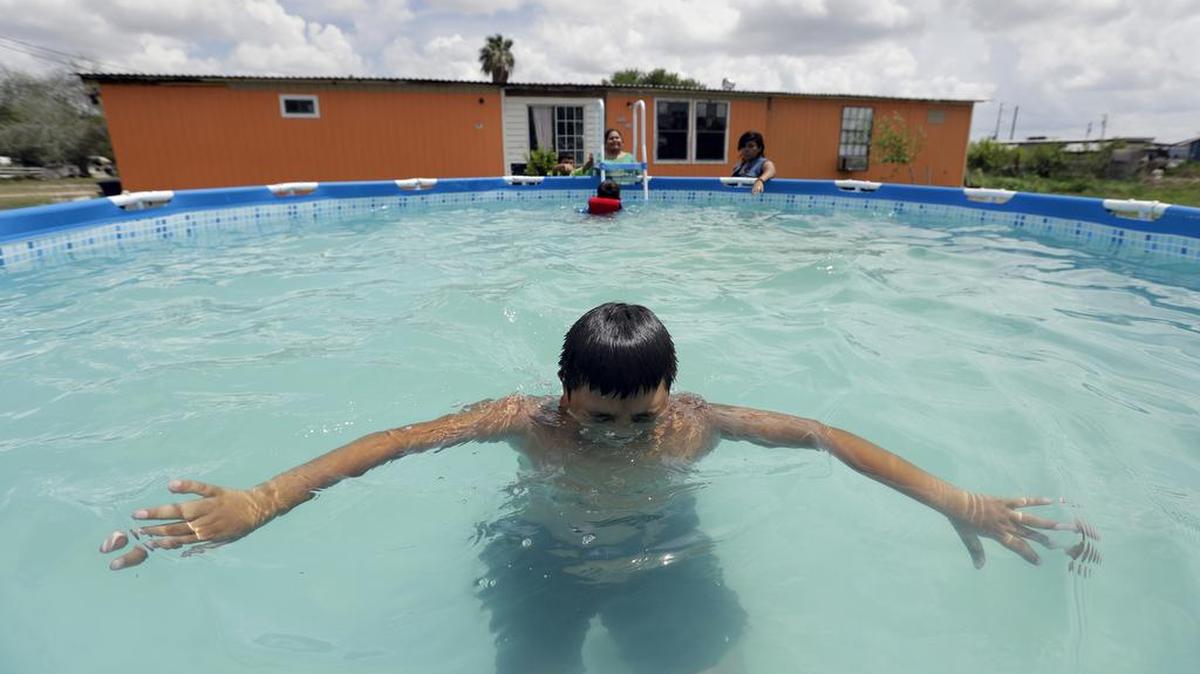 In this July 13 photo, Jose Ochoa plays in an above-ground pool at his home in the South Tower Estates colonia near Alamo, Texas. With no warning, Texas Gov. Greg Abbott this summer eliminated the state's Colonias Initiative Program that began in 1999 under George W. Bush as a bipartisan and humanitarian effort to improve living conditions and basic infrastructure.