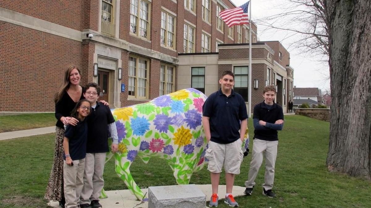 In this Feb. 29, 2016 file photo, teacher Kelly Gasior, left, and students, from left, Olivia Mashtaire, Ryan Lysek, Christian Vazquez and Tyler Lysek stand with a statue of a Buffalo that's been emblazoned with anti-bullying messages outside Lorraine Academy, Public School No. 72, in Buffalo, N.Y. One in every 5 middle and high school students has complained of being bullied at school and the number of reports of sexual assault on college campuses has more than tripled over the past decade, according to a federal study released Tuesday, May 16, 2017.