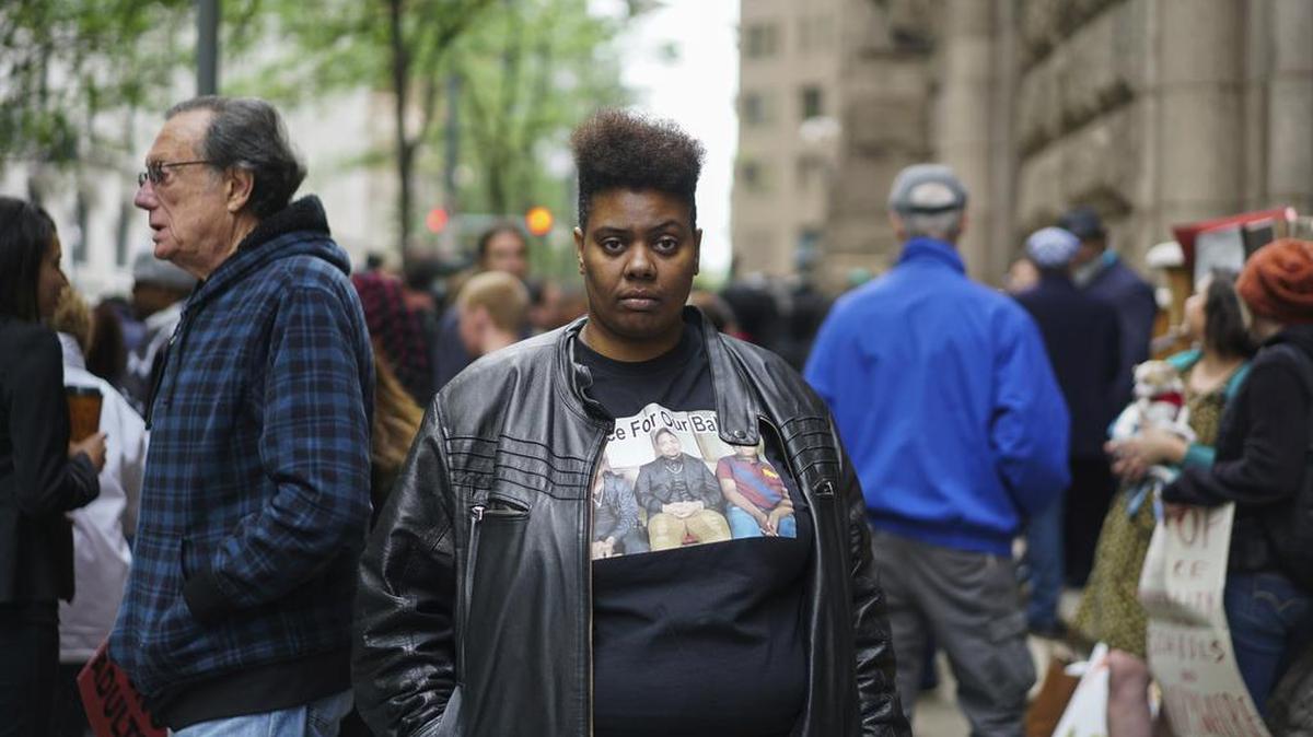 In this May 12, 2017, photo, Burgundi Russell, a plaintiff in a civil rights lawsuit against Woodland Hills High School, poses for a picture in Pittsburgh, Pa. Russell alleges that a school resource officer, Steve Shaulis, punched and knocked out a tooth of her son earlier this year. The Pittsburgh-area school with a history of racial tension created a culture of verbal abuse and excessive force that allowed resource officers to shock students with stun guns and body-slam them, according to a civil rights lawsuit filed Aug. 23.