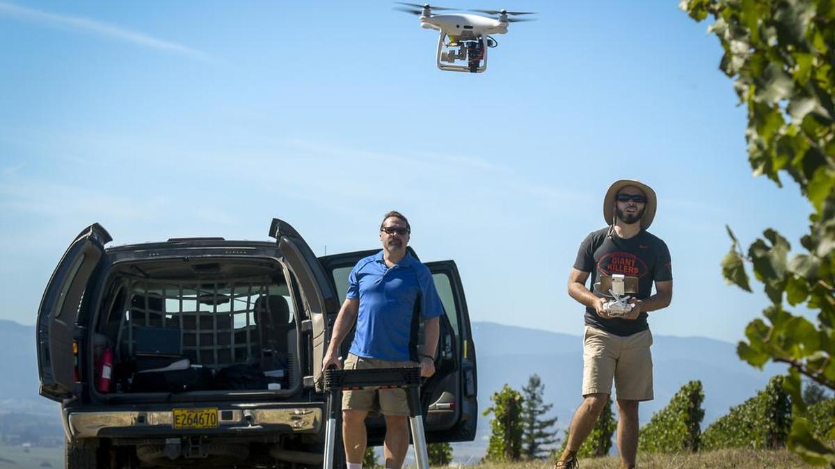 Michael Wing, director of the Aerial Information Systems Laboratory at Oregon State University, left, and doctoral candidate Cory Garms fly a survey flight with a DJI Phantom Pro 4 unmanned vehicle at an area vineyard, near Amity, Ore.