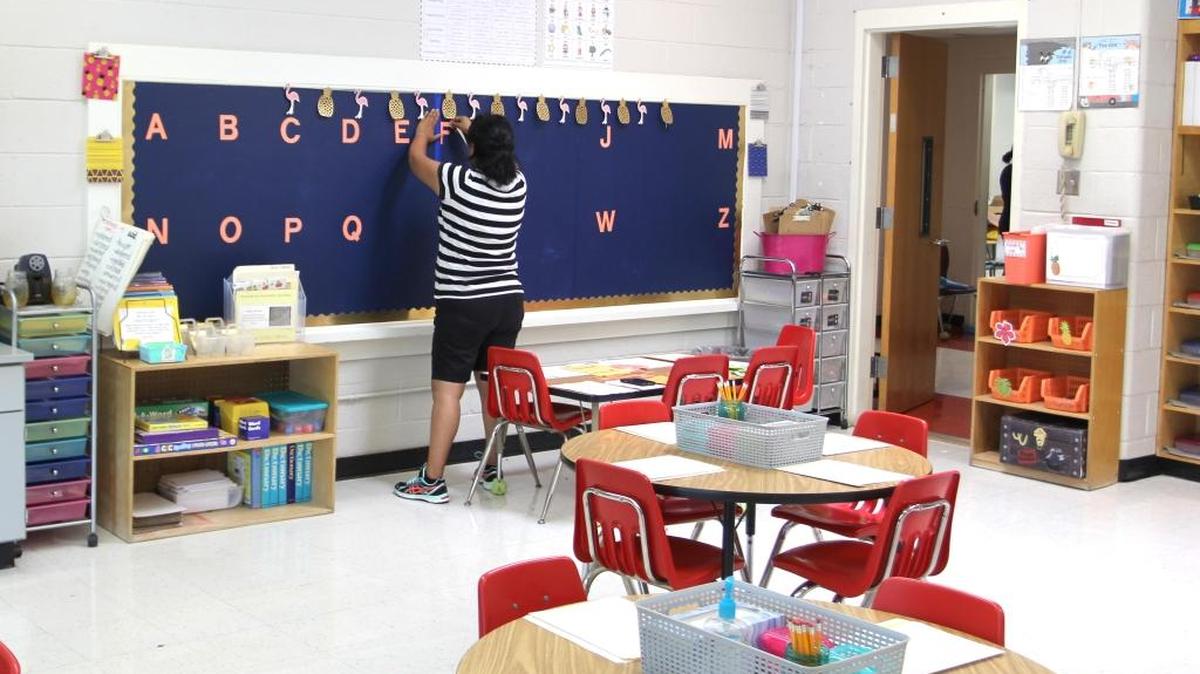 First-grade teacher Meghan Wilder prepares her classroom at Pearsontown Elementary School for the first day of school on Monday.