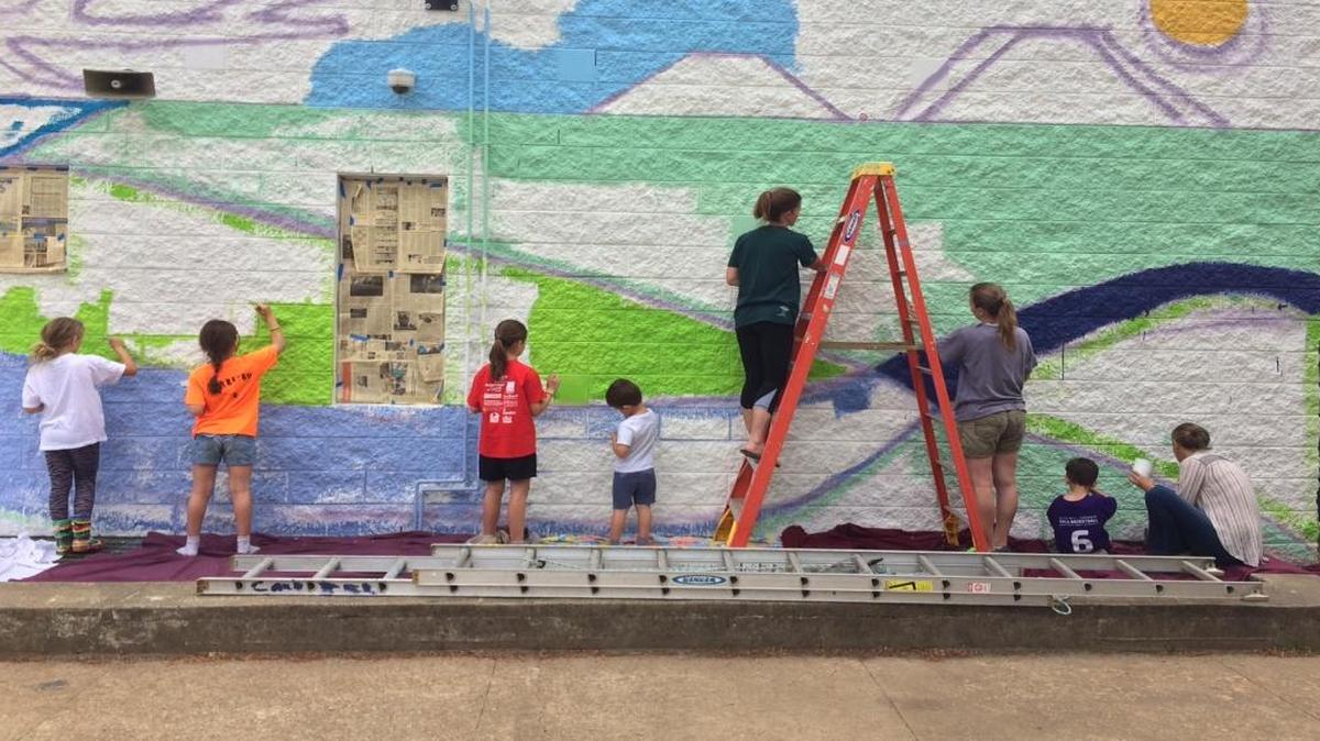 Students paint a mural as part of “Dibujando Nuestro Pueblo” (“Drawing Our Village”) a yearlong project at Frank Porter Graham Bilingüe elementary school in Chapel Hill. The project focused on ideas related to culture, home, identity, and unity and culminated in the mural in the school courtyard unveiled June 1. The project came together through a partnership between assistant principal José Nambo, school counselor Barbie Garayúa-Tudryn and two local artists, Mary Carter Taub and Amy Keenan Amago, who are also parents of students at the school. The project was funded by the school PTA, the Orange County Arts Commission and the Grassroots Program of the N.C. Arts Council.