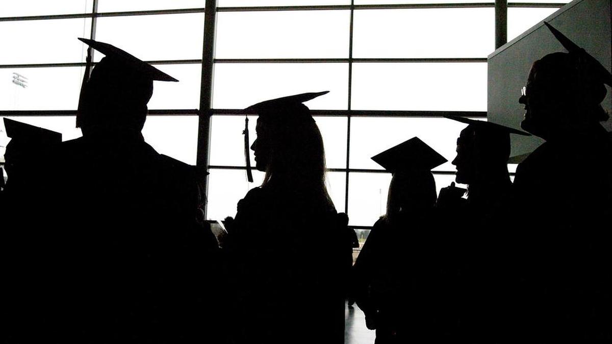 College graduates socialize before their commencement at the Convocation Center in Ypsilanti, Mich. Federal and state officials have launched the first national crackdown on companies that falsely promise debt relief for student loan borrowers. But critics say the Department of Education and its loan servicers expose consumers to fraud and fail to spot scams.
