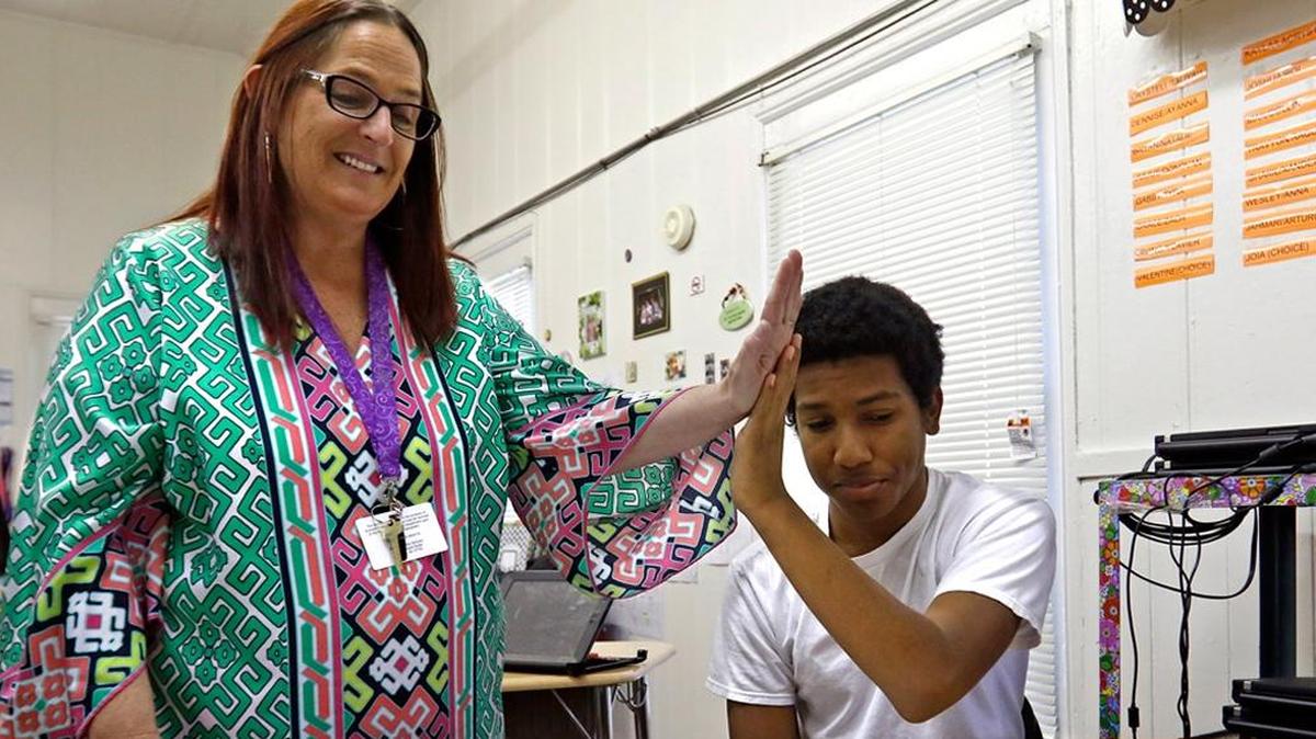 Lowe’s Grove Middle School teacher Jenny Duvall works with eighth-grader Julius Borunda as part of a Durham program to provide more challenging classes to low-income students with high potential.