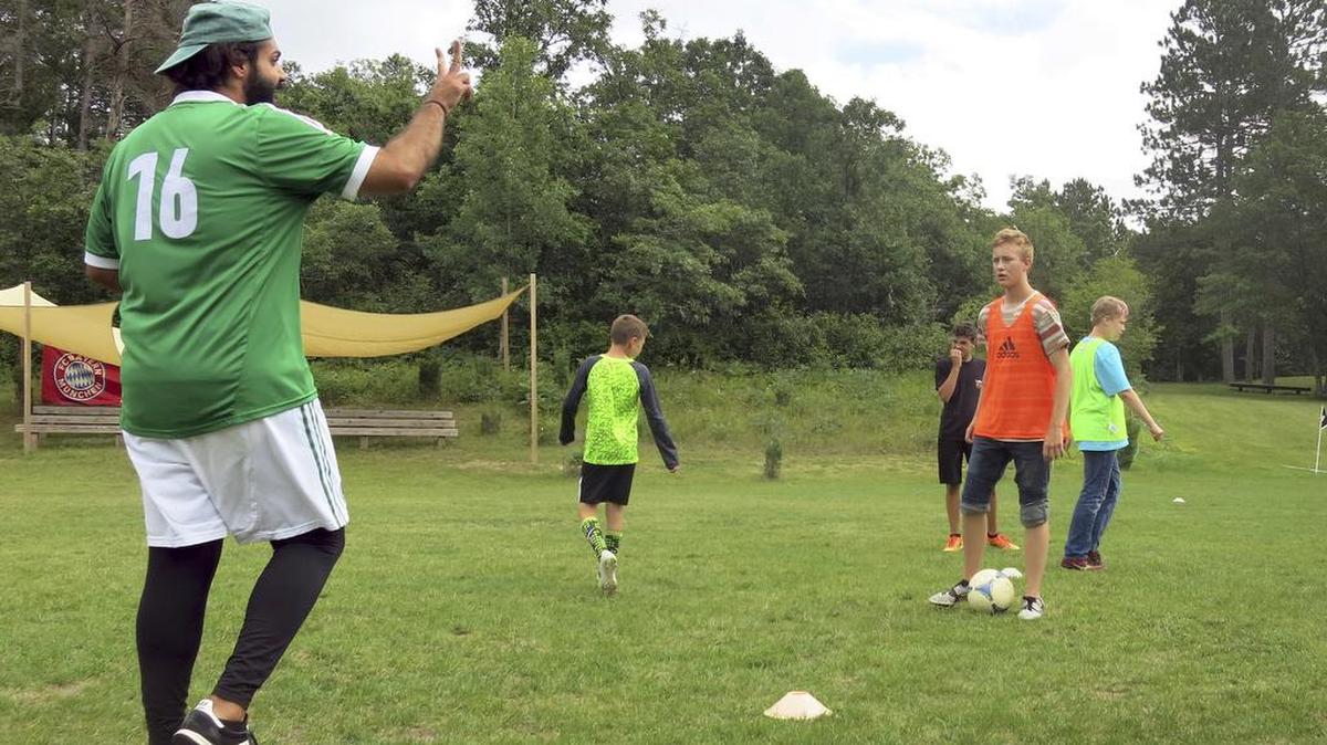 In a July 27, 2016 photo, German soccer coach Ersan Yesil drills campers on footwork at the Waldsee, in Bemidji, Minn.
