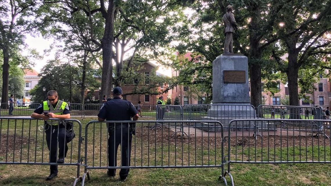Police stand behind barriers around Silent Sam statue in Chapel Hill on Tuesday.