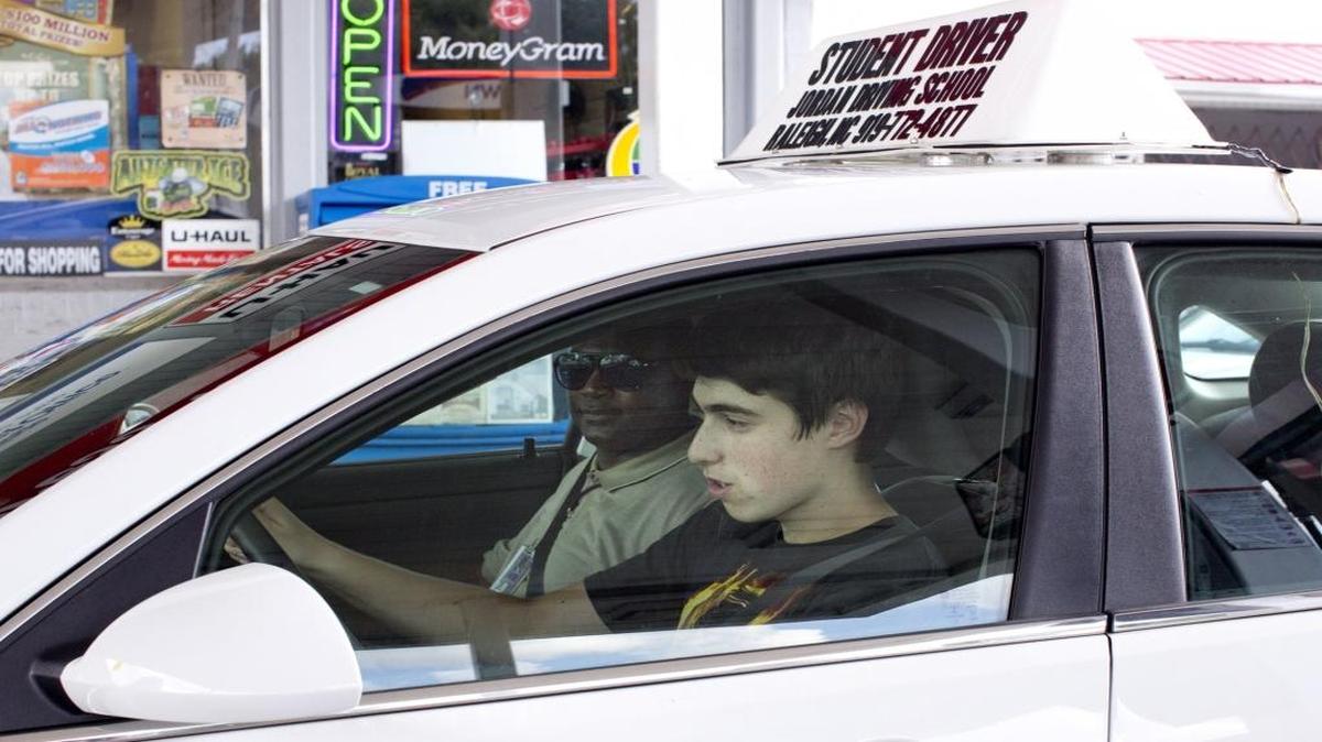 Asher Philips, 15, runs through a driving checklist alongside instructor Curtis Wilson during the behind-the-wheel portion of the driver’s education program run by Jordan Driving School on Aug. 19, 2015.