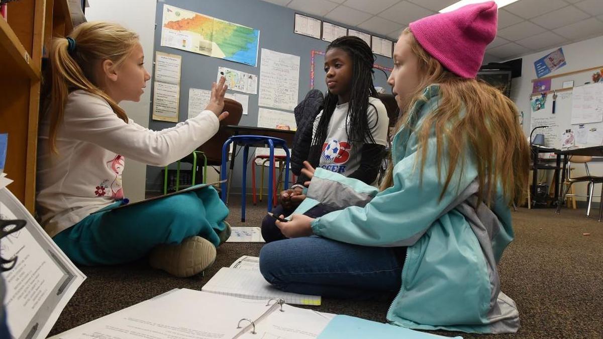 Washington Elementary school fourth-grader Averye Morrison (left) works with friends Kayla Lewis (center) and Pearl Hollingsworth on a math problem in Nancy Bergquist’s class in Raleigh on Thursday, Dec. 14, 2017.