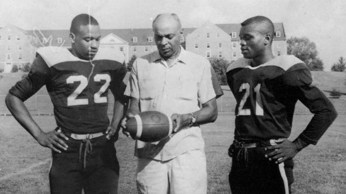 Richard Hicks (right, 21) is pictured with NCCU Coach Herman Riddick (center) and an unidentified player in a 1962 yearbook photo.