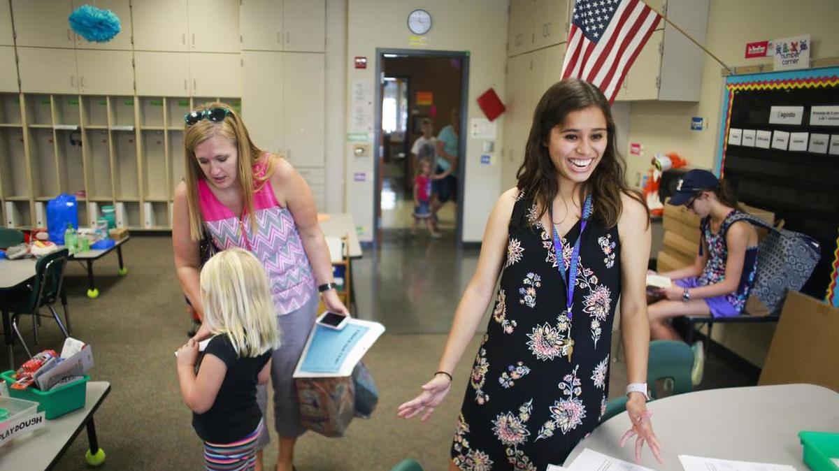 In this Aug. 8 photo, first grade and kindergarten Spanish language immersion teacher Marelis "Lisi" Miller, right, greets students and parents the day before school at Summit Elementary School, in Bloomington, Ind. For a brand-new teacher, the first day of class is just about as exciting and nerve-wracking as it was when they were kindergartners.