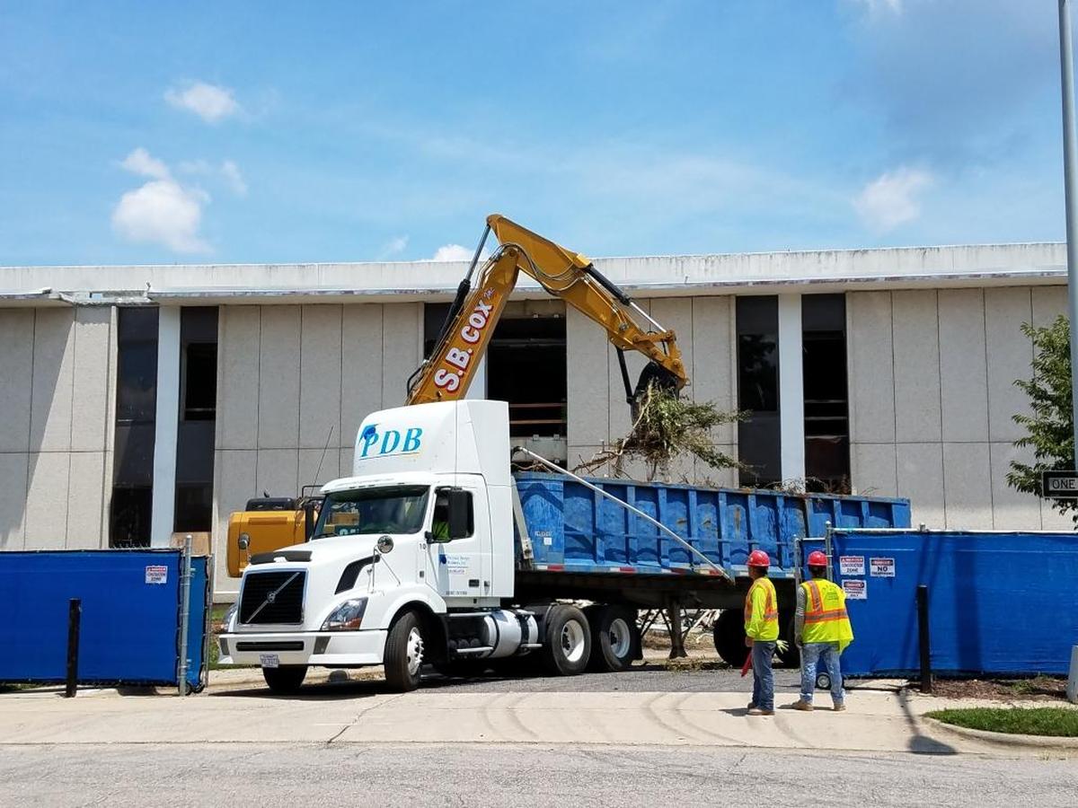 A construction vehicle clears tree branches from the grounds of the Durham County Main Library in downtown Durham on Thursday, July 13. When renovations are complete, the library entrance will be on Liberty Street.