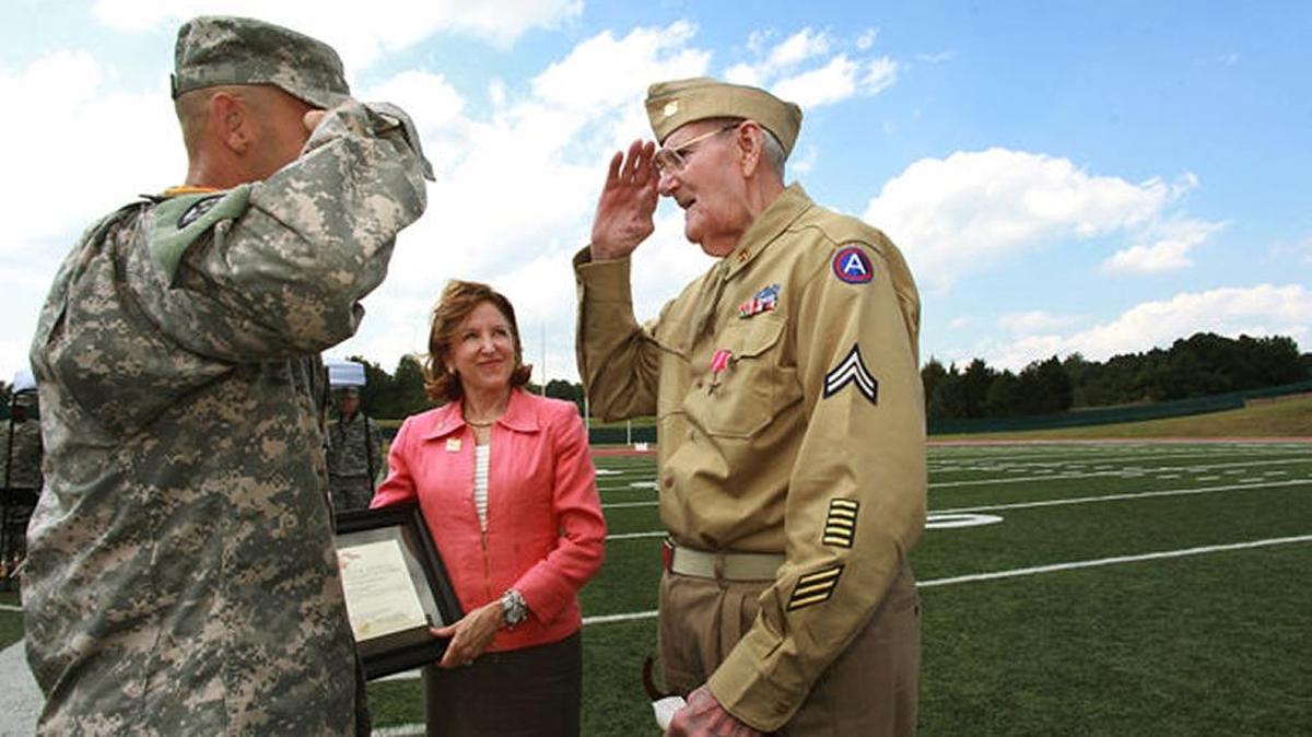 World War II veteran Merle “Jack” Hammersley salutes Brig. Gen. James Ernst after Ernst and then U.S. Sen. Kay Hagan. D-N.C., presented him with a belated Bronze Star on Sept. 13, 2013 at Durham County Memorial Stadium.