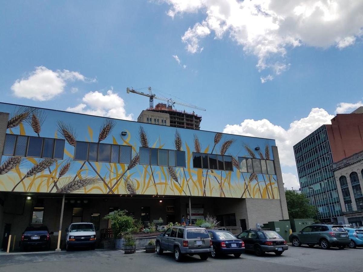 Ninth Street Bakery is in the old Herald-Sun building. Looking past its roof is the 21c Museum Hotel and One City Center with a construction crane.