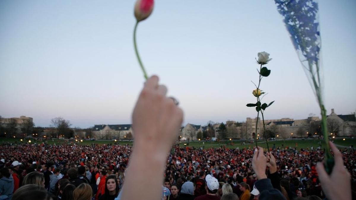 FILE-In this Tuesday, April 17, 2007 file photo, People gather for a vigil on the drill field following the shootings on the Virginia Tech campus in Blacksburg, Va. (AP Photo/Casey Templeton, File)