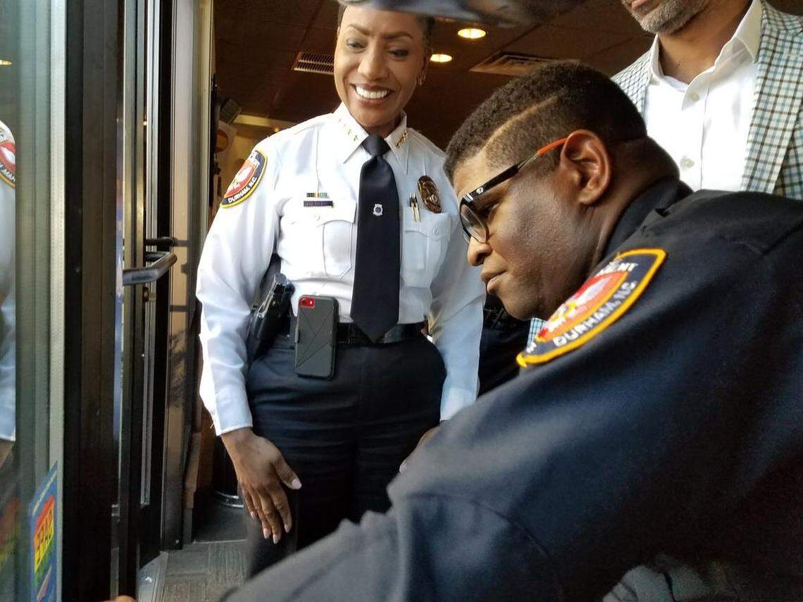 Durham Police Chief Cerelyn Davis watches as DPD Officer Charles Strickland, the department’s LGBTQ liaison, affixs a “Safe Place” sticker to the front window of the Starbucks on Guess Road on Wednesday, Oct. 24, 2018.
