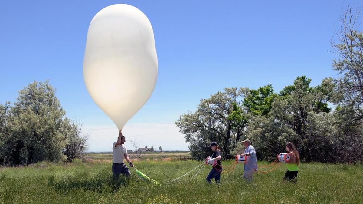 Montana State University Eclipse Ballooning Project team members Garrett Hilton, left, Katherine Lee, Berk Knighton and Micaela Moreni prepare to launch a high-altitude balloon during a test flight Wednesday, June 22, 2017 near Rexburg, Idaho. During the August 21, 2017 solar eclipse, teams across the nation will live-stream video footage of the eclipse as part of the MSU-led project.