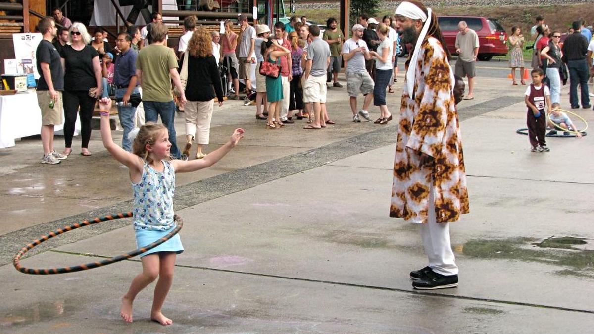 Margo Russell, 6, of Durham, impresses Stafford Berry Jr., associate artistic director of the Chuck Davis African American Dance Ensemble, with her Hula Hooping at a block party kicking off the 2010 American Dance Festival block party kickoff. News & Observer file photo.