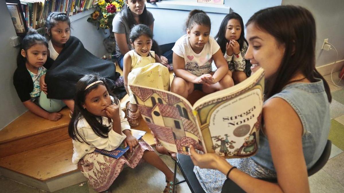 In this Wednesday, Aug. 7, 2013 photo, Sophie Mortner, foreground right, reads aloud for youngsters attending LitCamp, a summer reading program offered through the nonprofit literacy organization LitWorld, in the Harlem neighborhood of New York.
