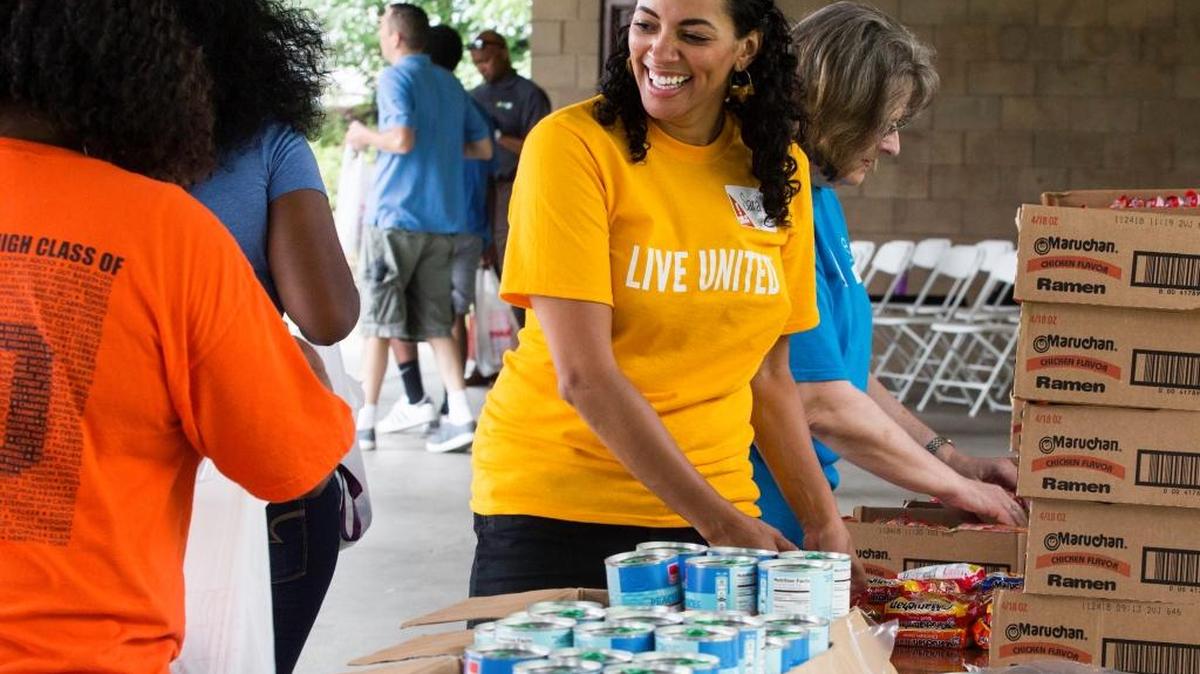 Sara Stephens helps fellow volunteers collect items to create meal and reading kits for Durham area students on June 21, 2017, in Durham, NC.