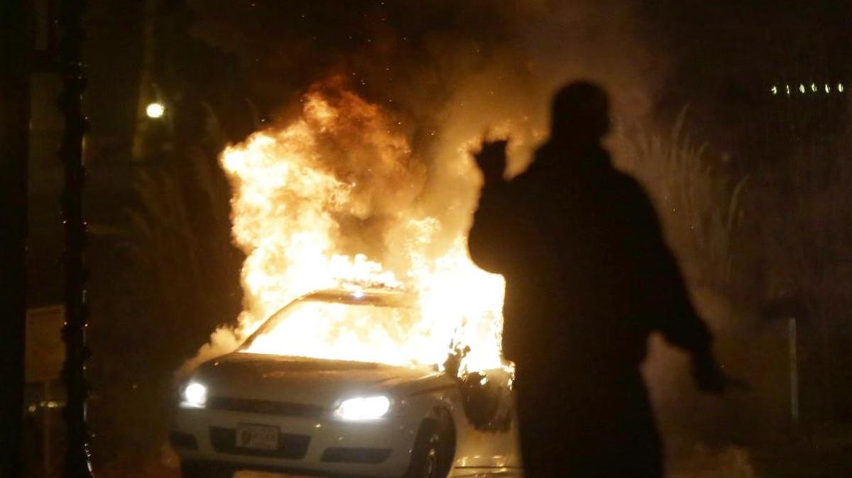 In this Nov. 24, 2014 file photo, a police car is set on fire after the announcement of the grand jury decision in the shooting of Michael Brown in Ferguson, Mo.