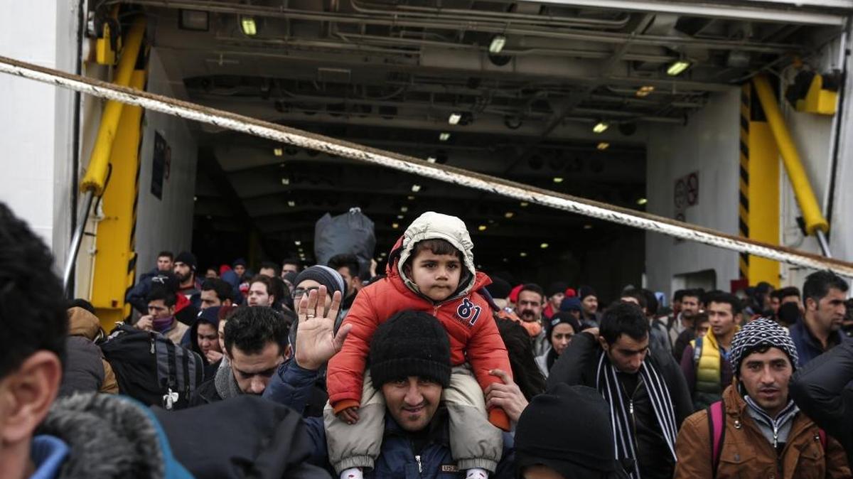 Refugees and migrants disembark from a ferry after their arrival at the port of Piraeus near Athens, on Saturday, Jan. 23, 2016.