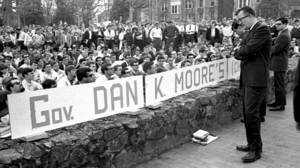 Civil rights activist Frank Wilkinson, barred from the UNC campus, prepares to speak to students across the stone wall between McCorkle Place and Franklin Street at a rally in 1966. The university has a fraught history with free speech issues.