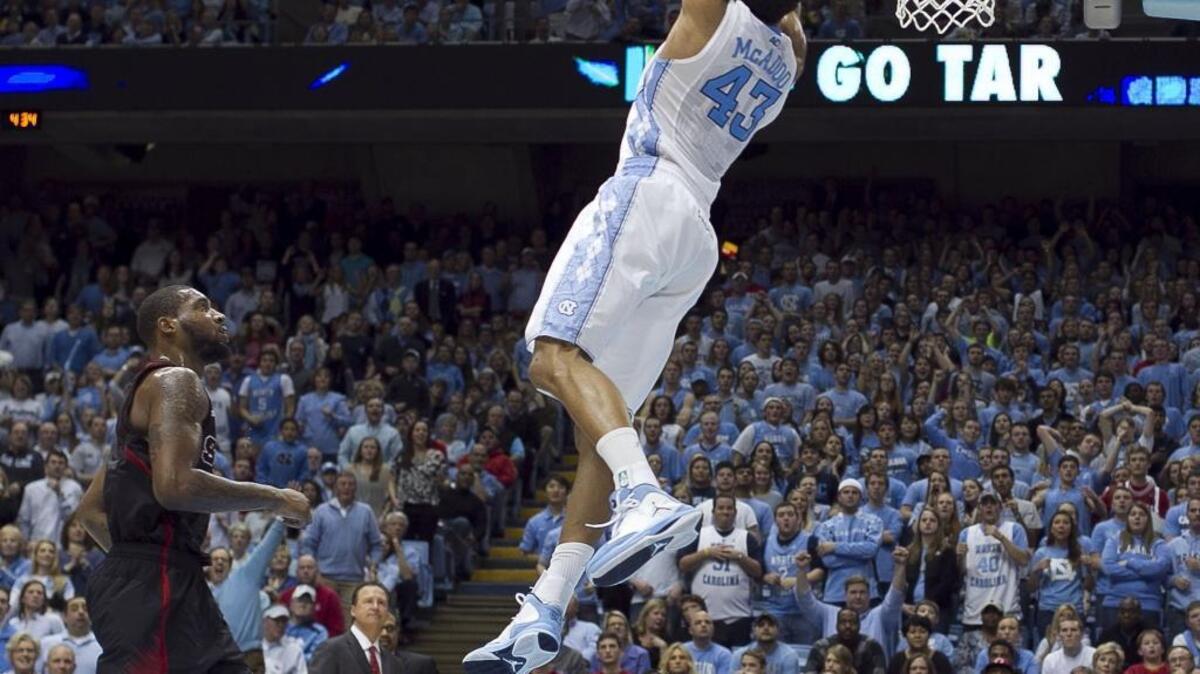 UNC's James Michael McAdoo (43) does a reverse dunk during a 2013 game with N.C. State. Now with the NBA’s Golden State Warriors, McAdoo will be watching the Tar Heels in Monday night’s NCAA Tournament final in Phoenix.