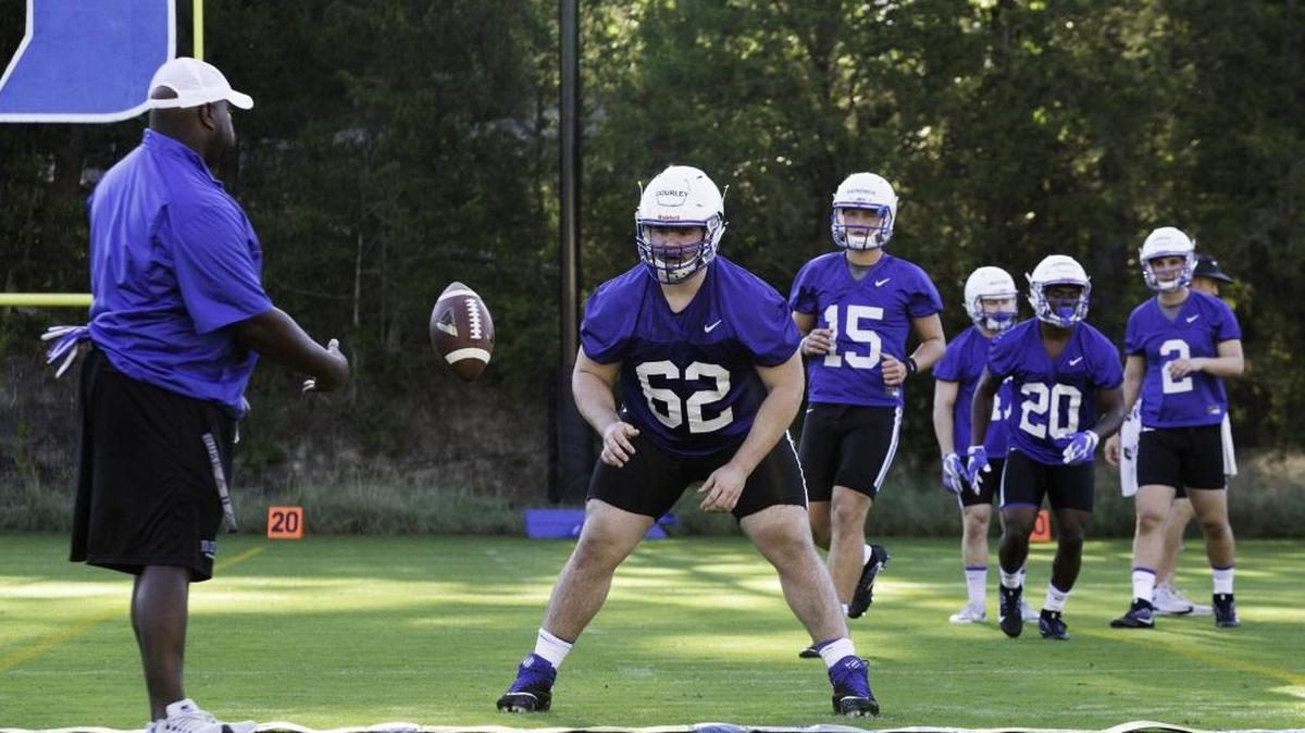 Alex Gourley, center, catches the ball during Duke’s first football practice of the season in July 31.