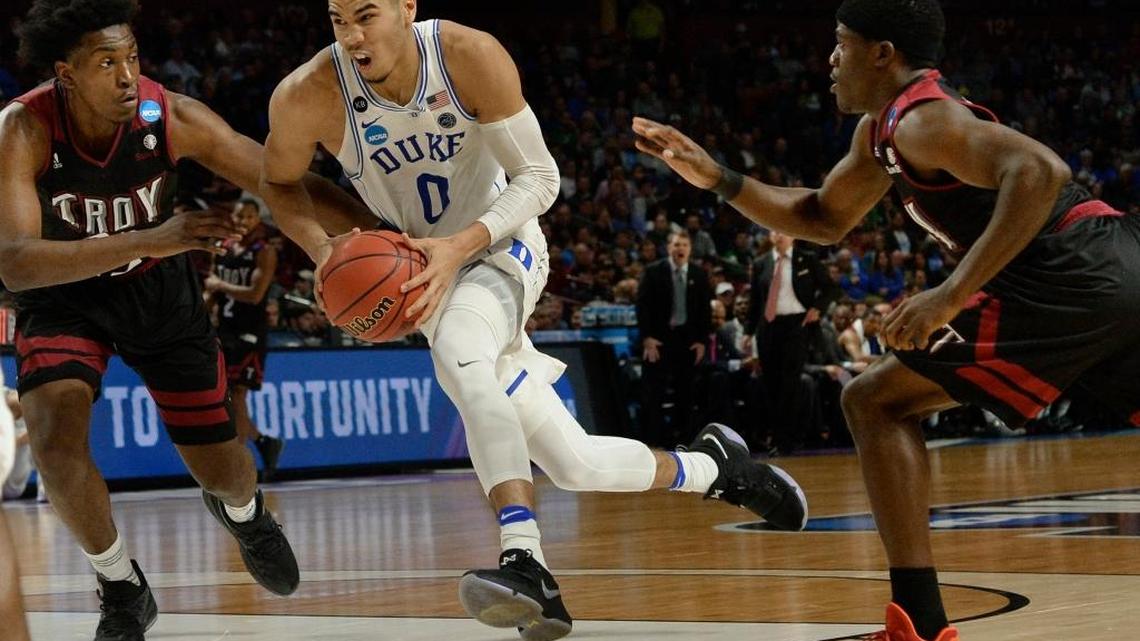 Duke forward Jayson Tatum (0) races between Troy forward Jordon Varnado (23) and teammate guard Kevin Baker (0) to go in to score against at the NCAA tournament on March 17, 2017, at the Bon Secours Wellness Arena in Greenville, S.C.