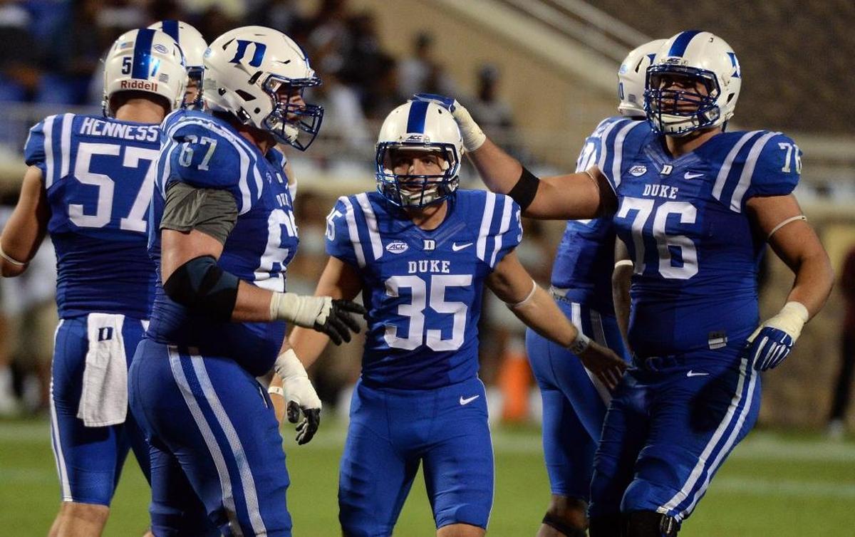 Duke place kicker Ross Martin, middle, is congratulated by teammate offensive tackle Gabe Brandner, right, after kicking an extra point in September 2015.