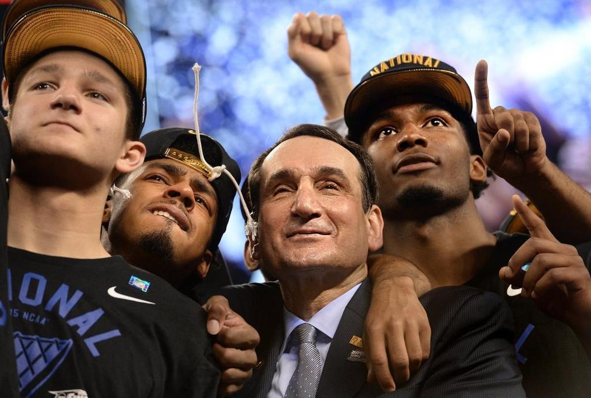 Duke head coach Mike Krzyzewski stands with, left to right, guard Grayson Allen, guard Quinn Cook and forward Justise Winslow after beating Wisconsin 68-63 for the 2015 NCAA national championship.