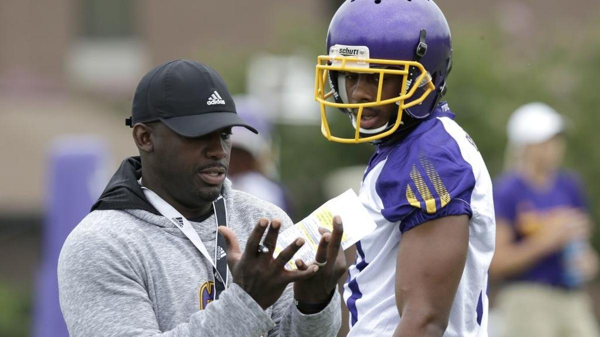 ECU football coach Scottie Montgomery, left, speaks with wide receiver Jimmy Williams during an August 2017 practice.