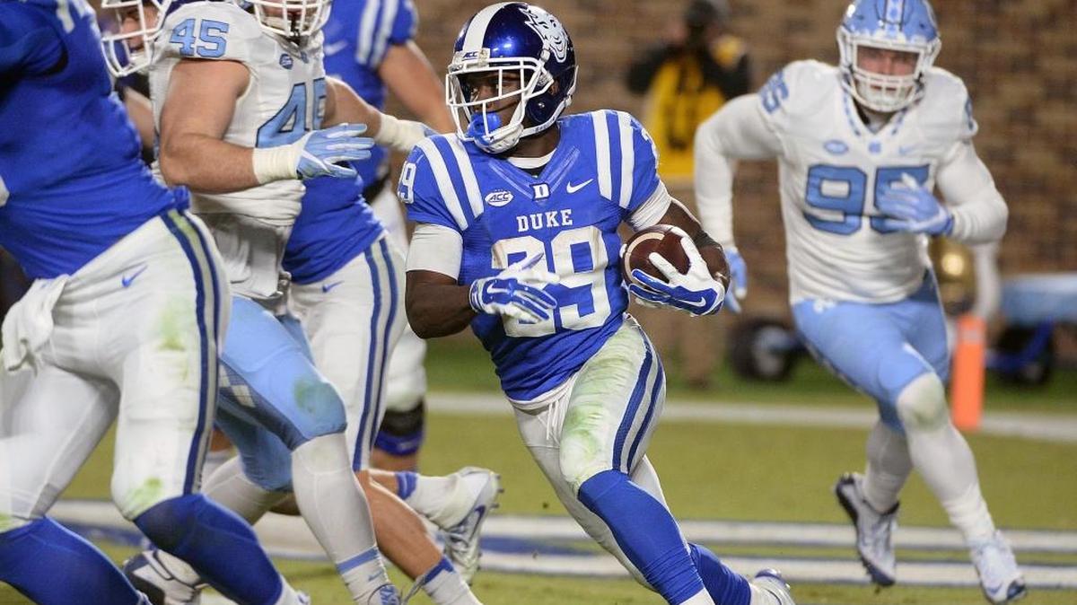 Duke running back Shaun Wilson, middle, heads for a first down against UNC in 2016.