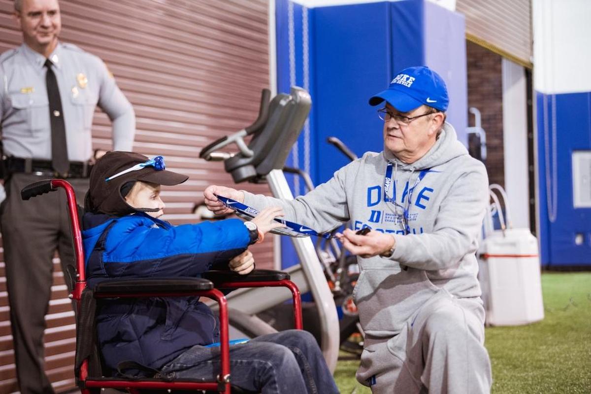 Duke football coach David Cutcliffe visits with 13-year-old Howell Brown during a team practice session last February. Brown died after a five-year battle with cancer on Friday.