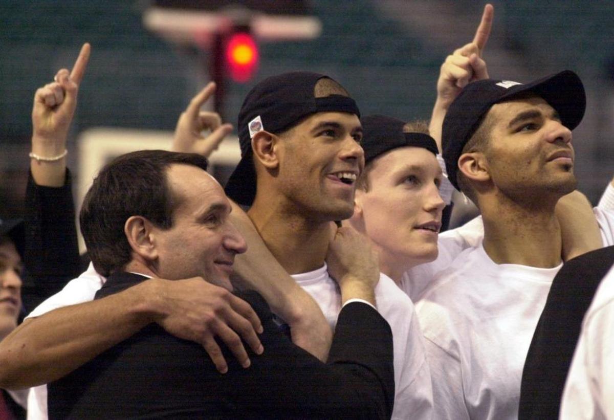 Duke coach Mike Krzyzewski hugs Shane Battier as Mike Dunleavy, and Carlos Boozer watch a video following the trophy presentation after the Blue Devils 82-72 NCAA championship win over Arizona in 2001.