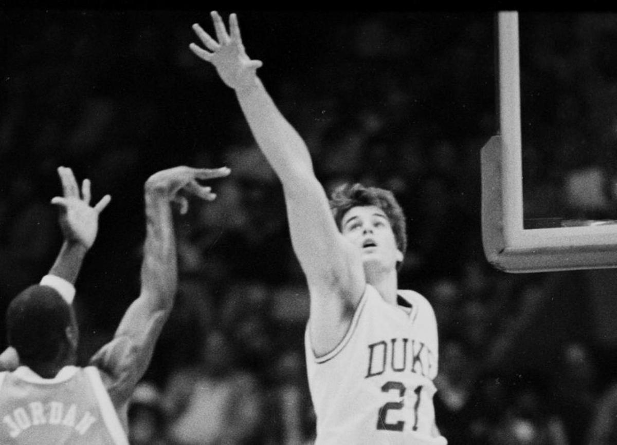 North Carolina’s Michael Jordan, left, shoots as Duke’s Jay Bilas defends during the March 10, 1984 ACC tournament semifinal game in Greensboro.