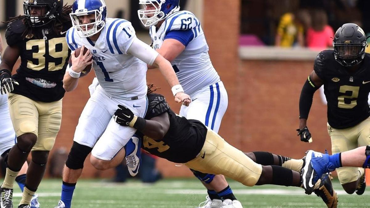 Thomas Sirk (1) of the Duke Blue Devils avoids a tackle by Wendell Dunn (14) of the Wake Forest Demon Deacons during a 2015 game at BB&T Field in Winston-Salem.