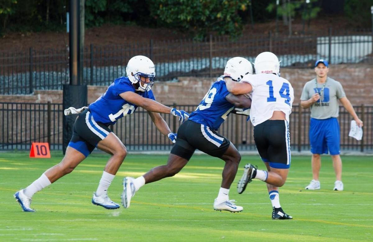 Quay Chambers, left, Shaun Wilson and Bryon Fields Jr. run a drill during the first Duke football practice on Monday.