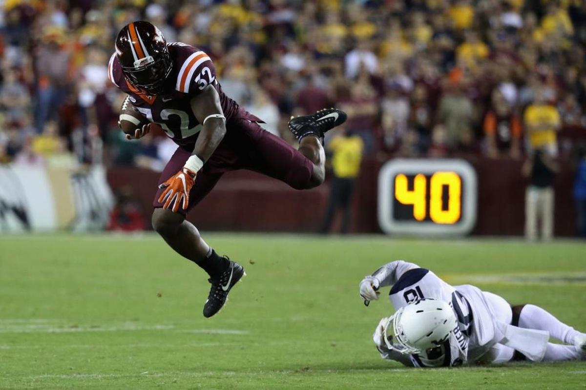 Virginia Tech running back Steven Peoples, left, is tripped up by West Virginia safety Toyous Avery on Sunday.