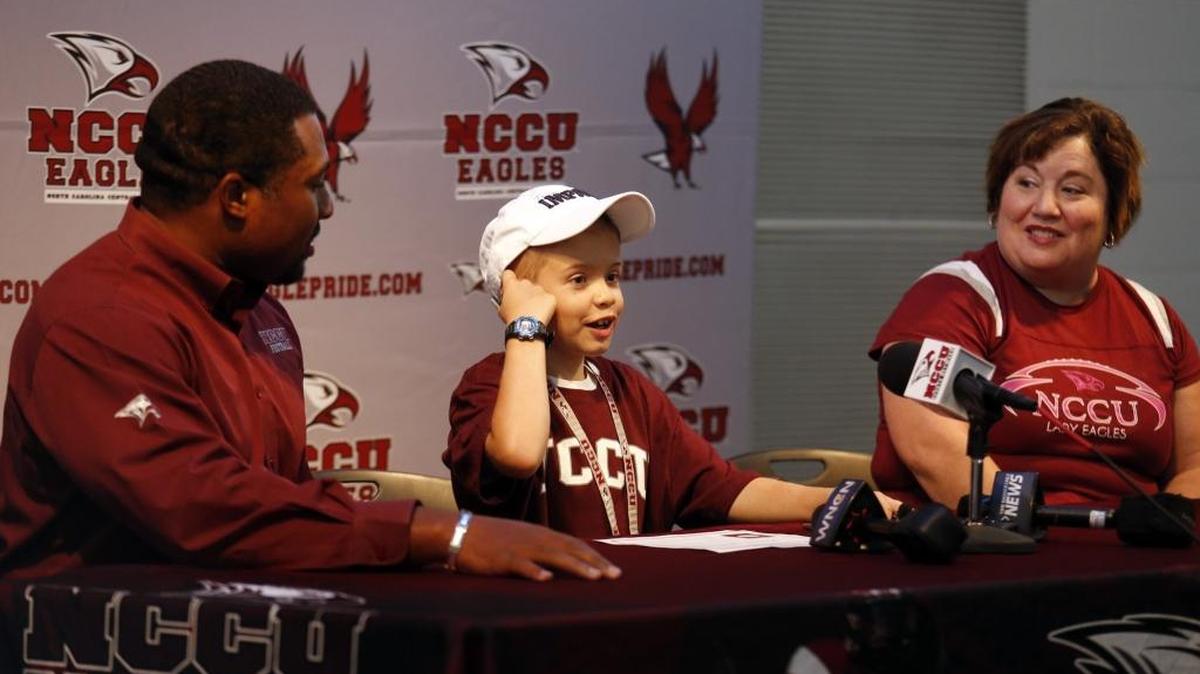 Howell Brown III answers questions during a news conference alongside his mother, Sue Brown, and N.C. Central head football coach Jerry Mack, left, during a day with the N.C. Central football team on August 10, 2014. Brown died on August 25, 2017, after battling cancer for five years.
